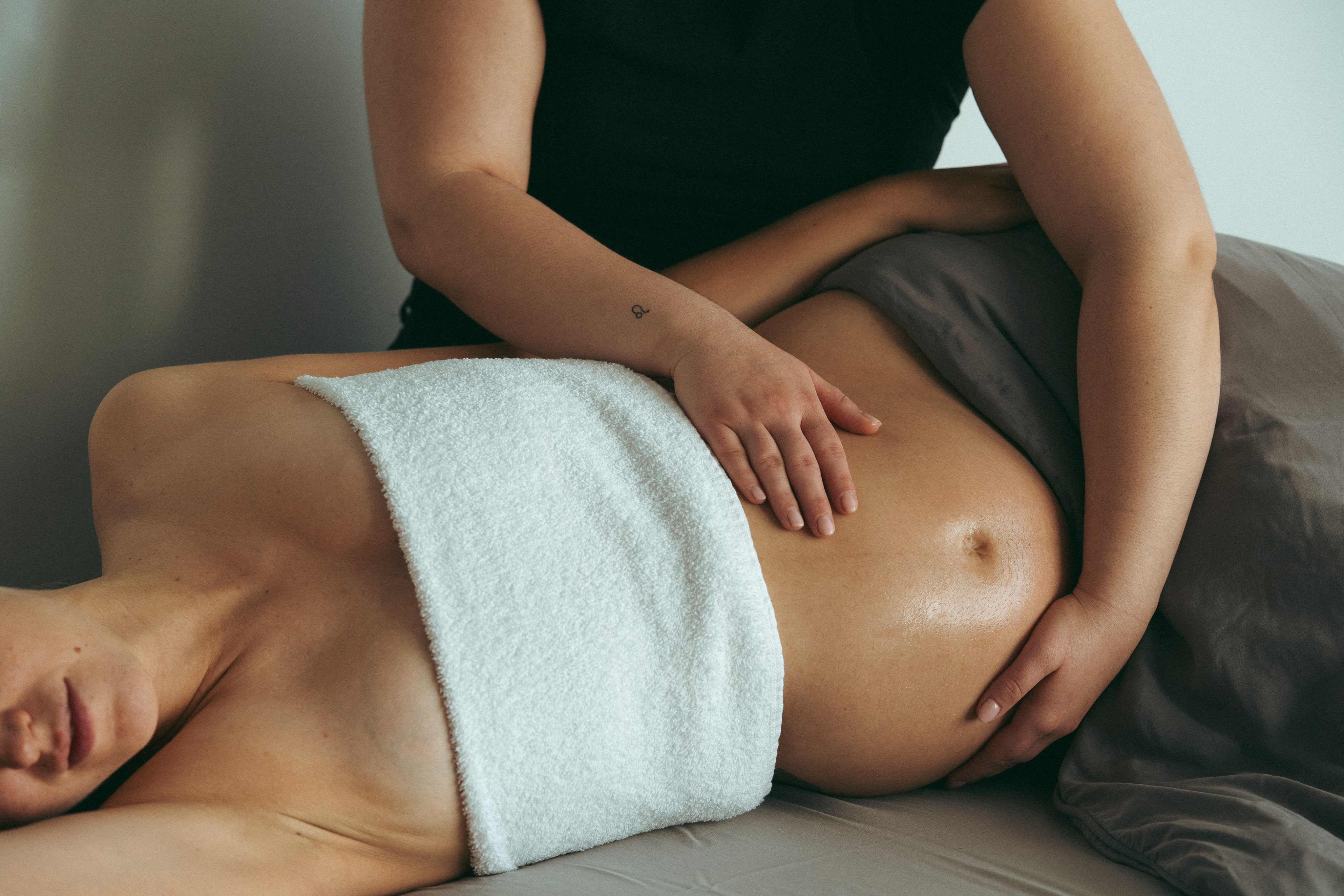 Pregnant woman lying comfortably while receiving a gentle spa treatment.