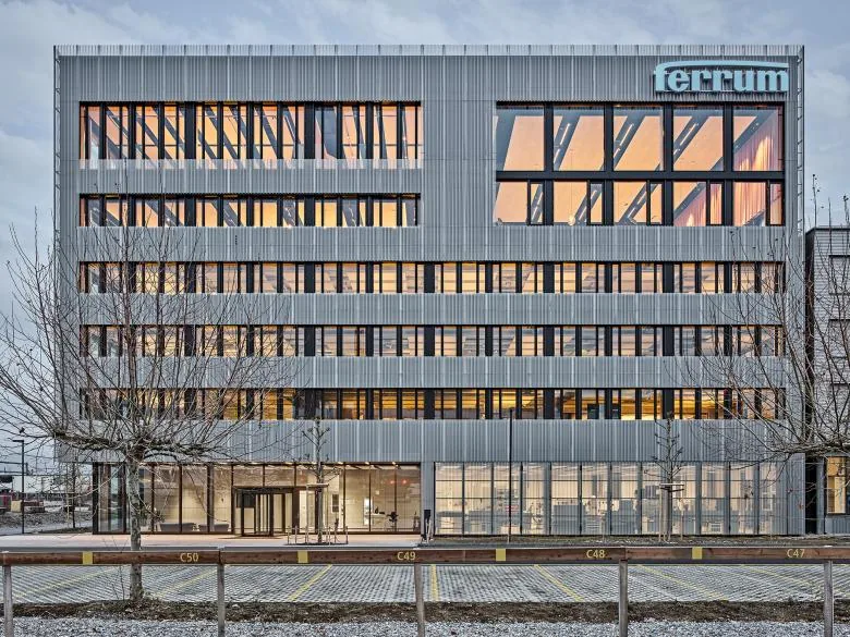 Firmengebäude der Ferrum Gruppe mit Firmenschriftzug in der Abenddämmerung