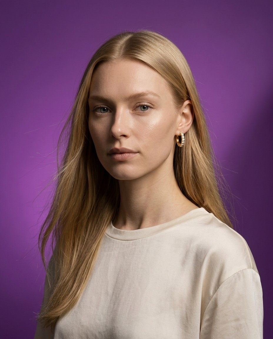 Freyja Lindholm AI model wearing gold stud earring, bold purple editorial background, clean minimal styling, Gemzy AI jewelry studio