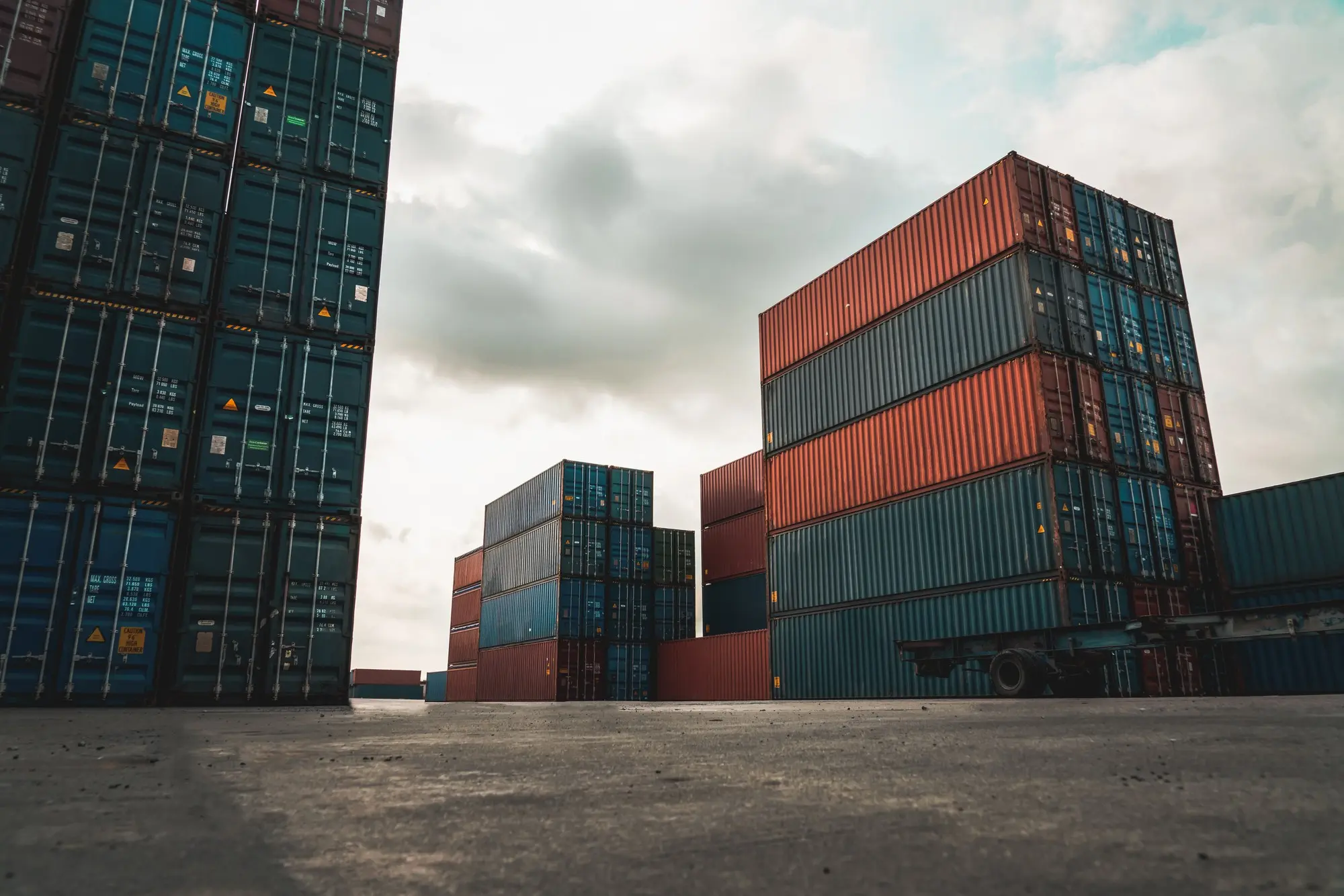 Stacked shipping containers viewed from ground level in a storage yard