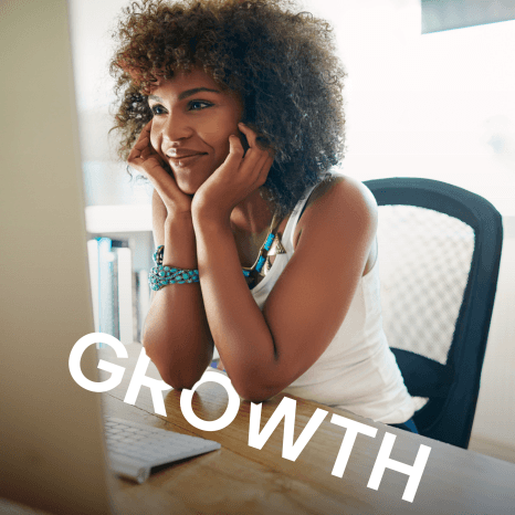 A smiling woman with curly hair sitting in front of a laptop, with the word "GROWTH" prominently displayed in the foreground.
