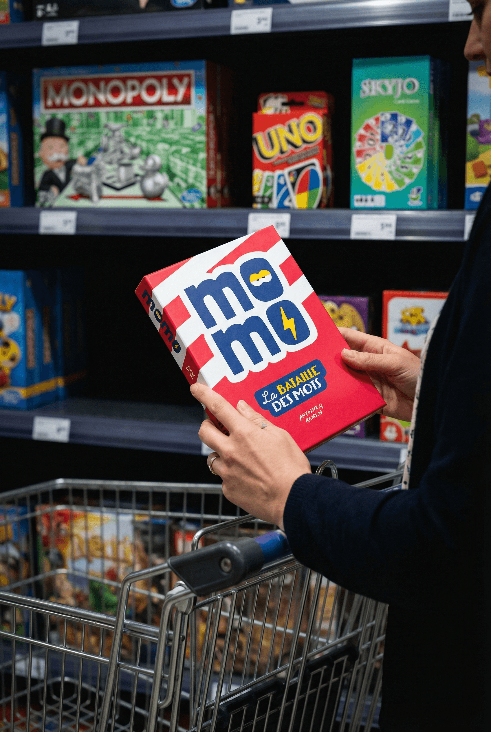 Une personne prenant Momo depuis une étagère dans une boutique de jeu