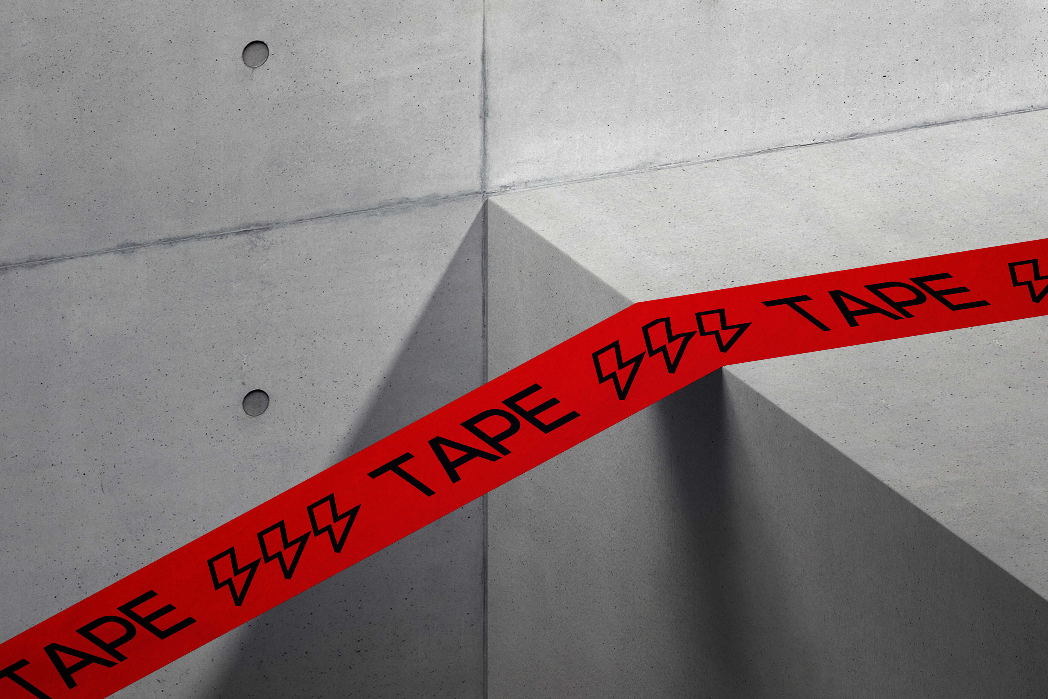 Red printed tape wrapped across concrete corner