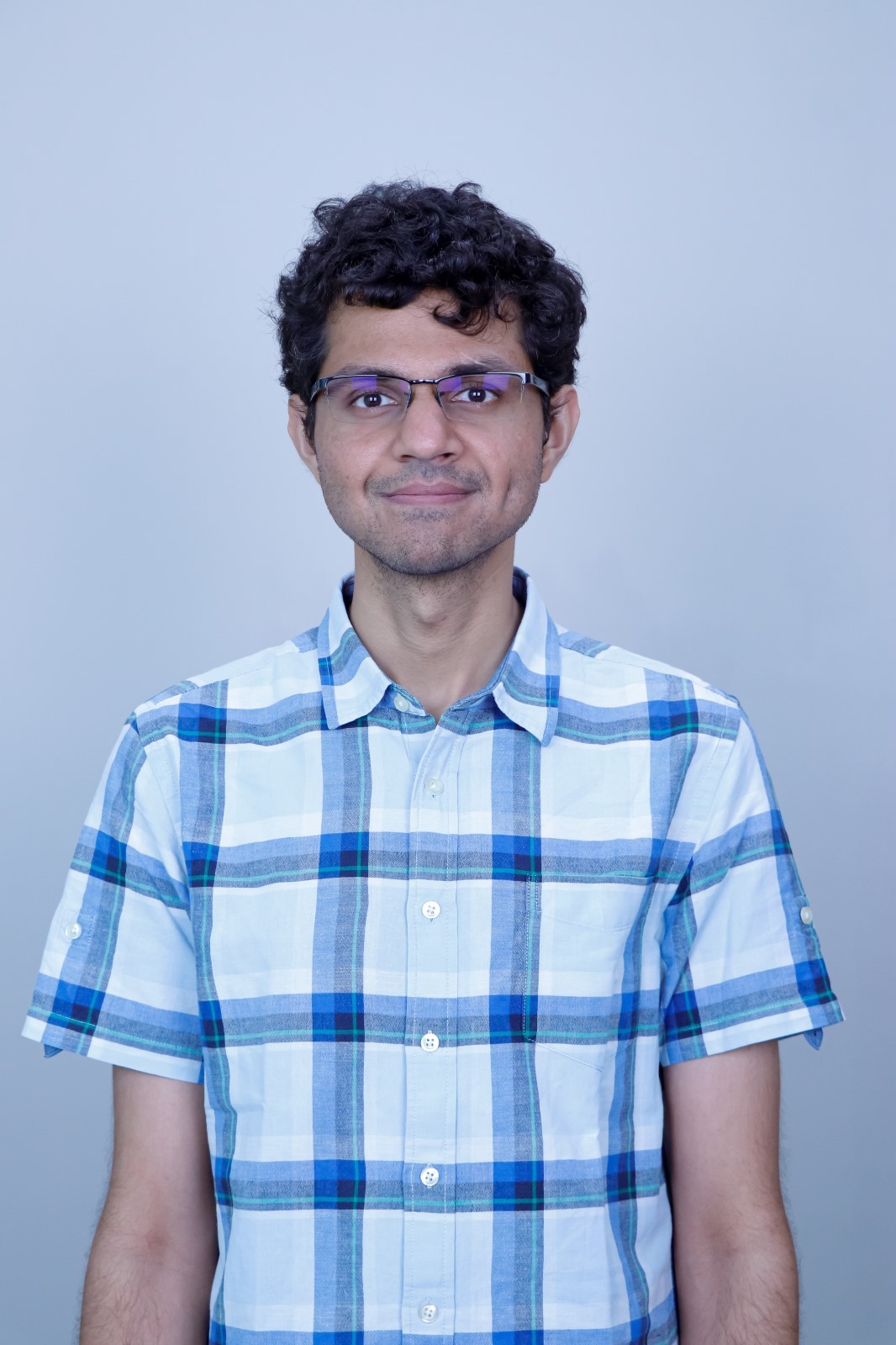 Man with arms crossed in modern office workspace.