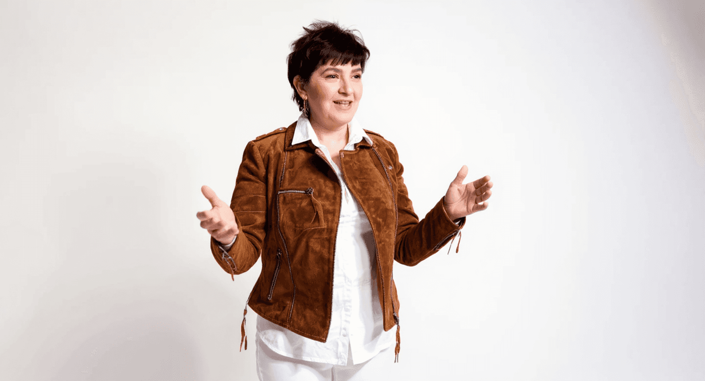 Change subject's posture to gesturing, as if explaining something while being filmed