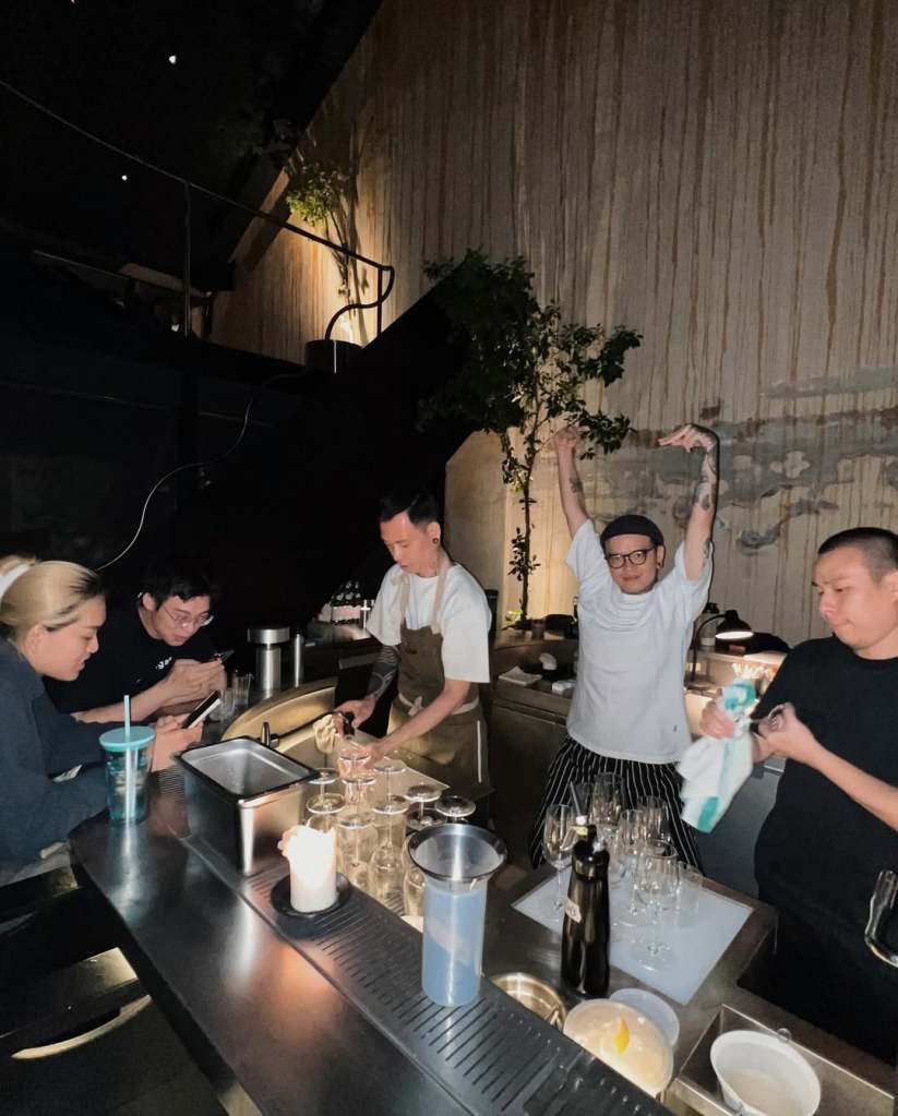 A lively kitchen scene at LUCKYHOLE with chefs preparing drinks and food, showcasing teamwork and enthusiasm.