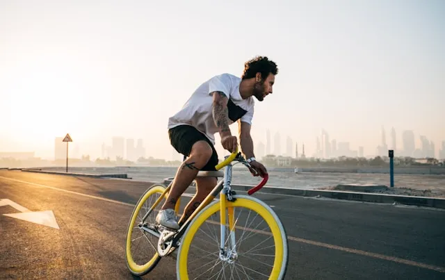 Man cycling through a city landscape in warm morning light