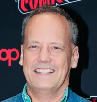 Dee Bradley Baker headshot in front of Comic Con banner