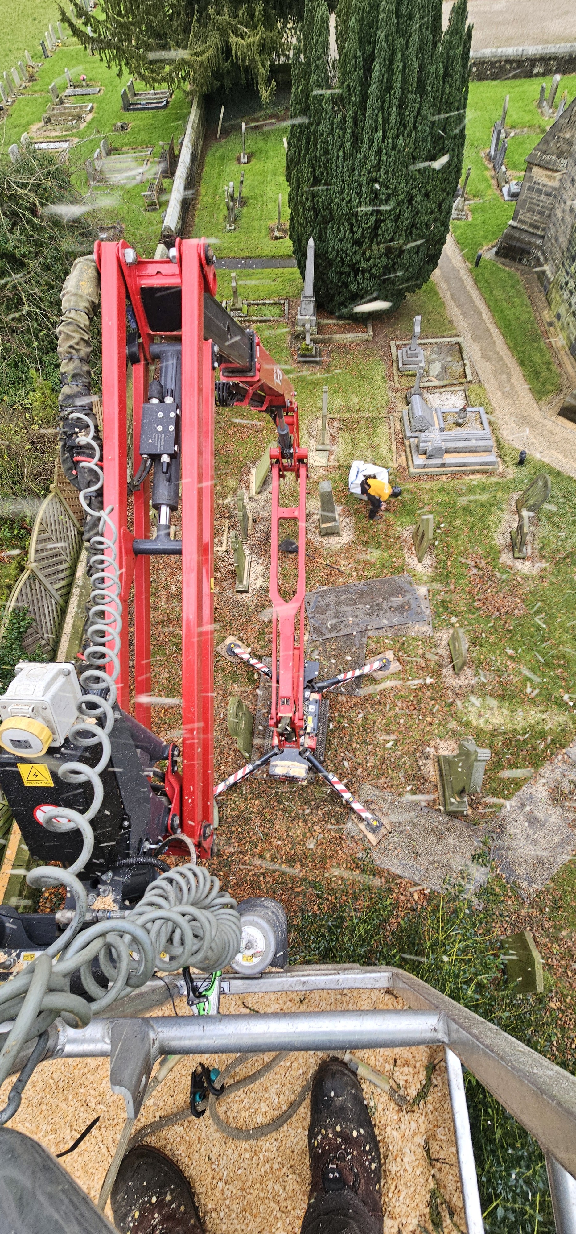 Silhouette of a cherry picker lift against sky