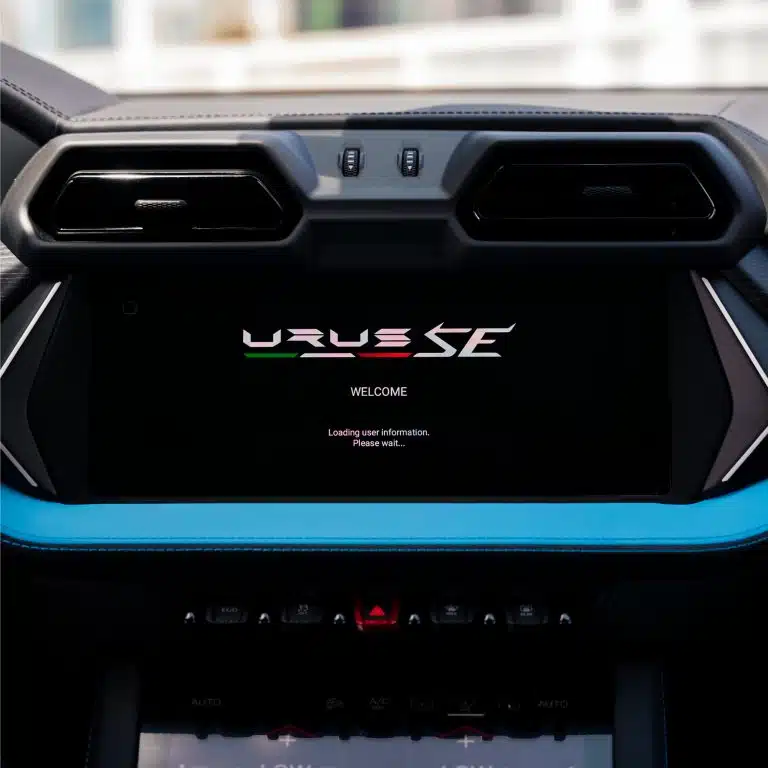 Detailed view of the infotainment screen and climate controls in the Lamborghini Urus SE, showcasing the modern digital interface and blue trim.
