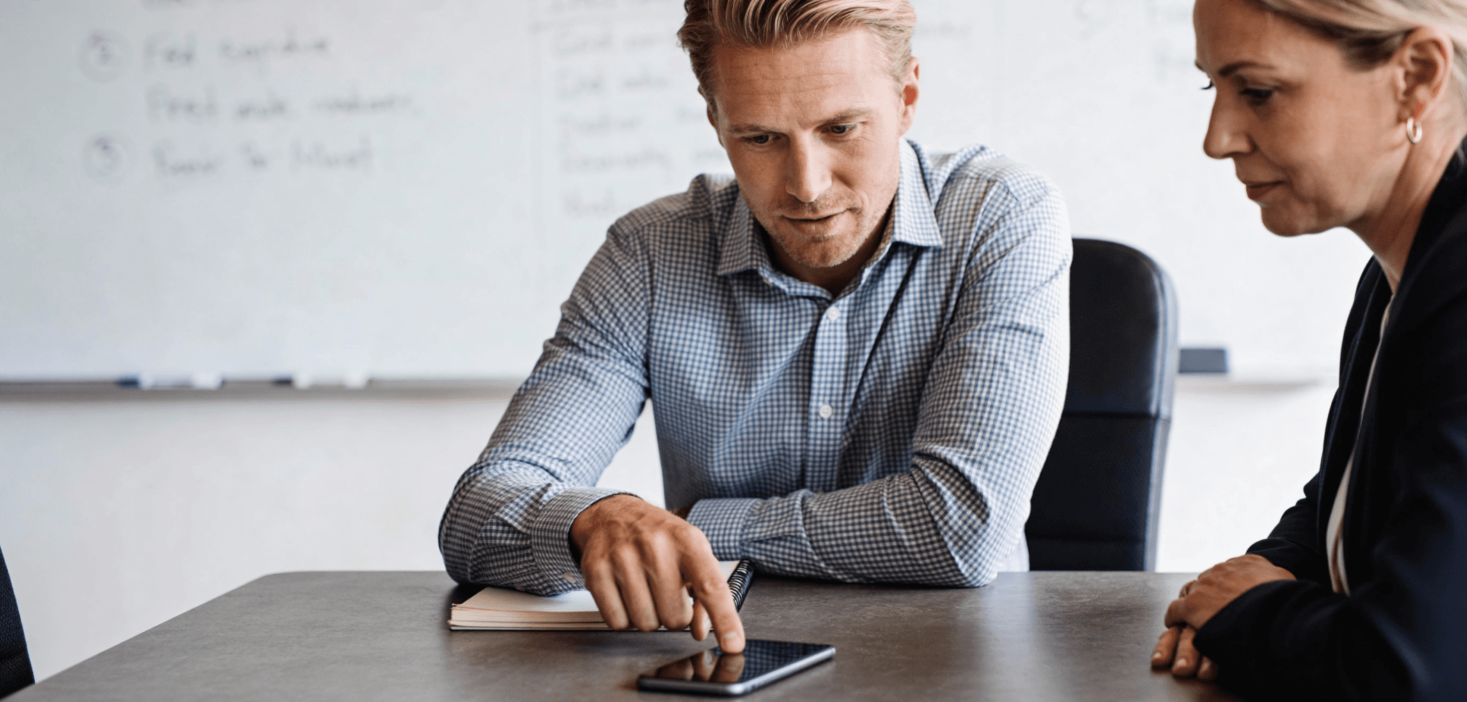 UX researcher and participant reviewing a mobile app prototype on a smartphone during a usability testing session.