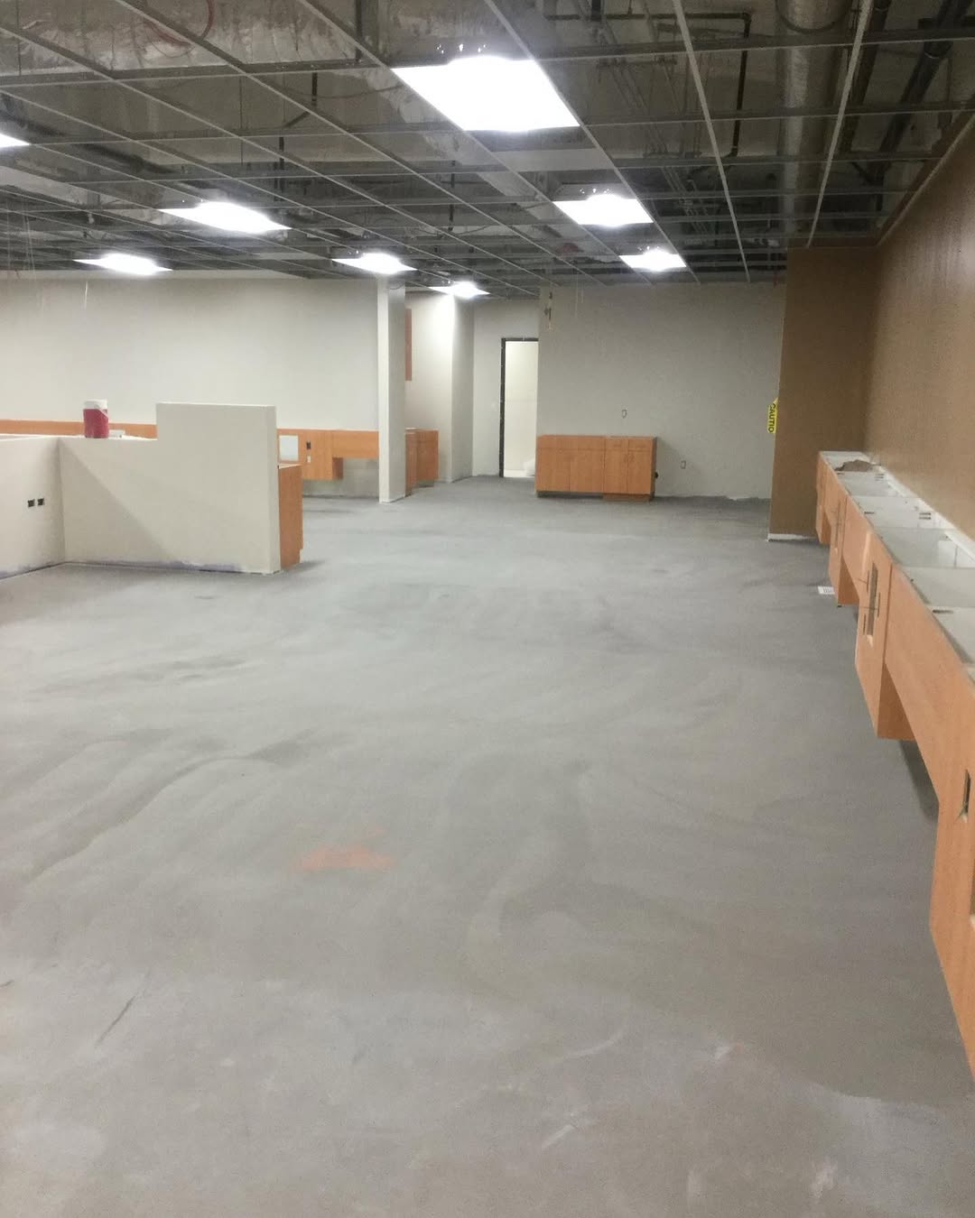 Bare concrete slab across an open facility floor before installation