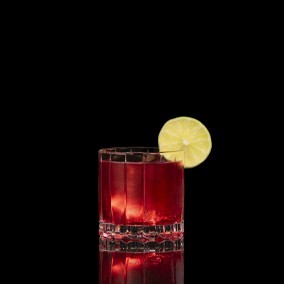 A closeup of a Vodka Cranberry drink against a dark background.