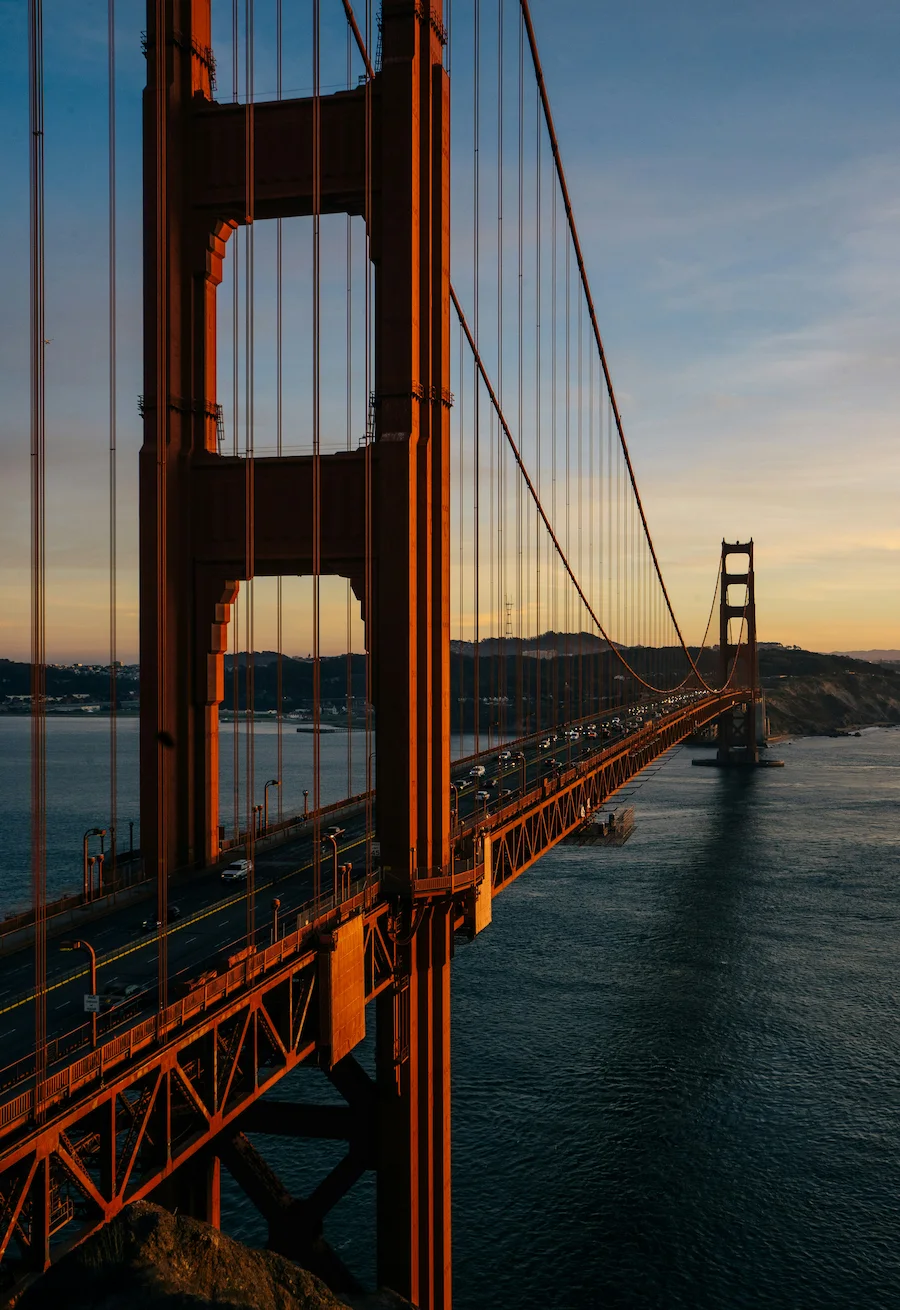 Golden Gate Bridge at sunset, San Francisco, with orange towers over the bay.