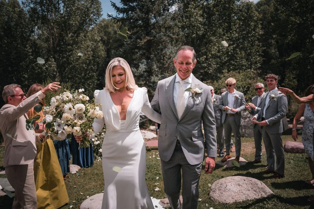 Newlyweds walking through bubbles after their outdoor ceremony