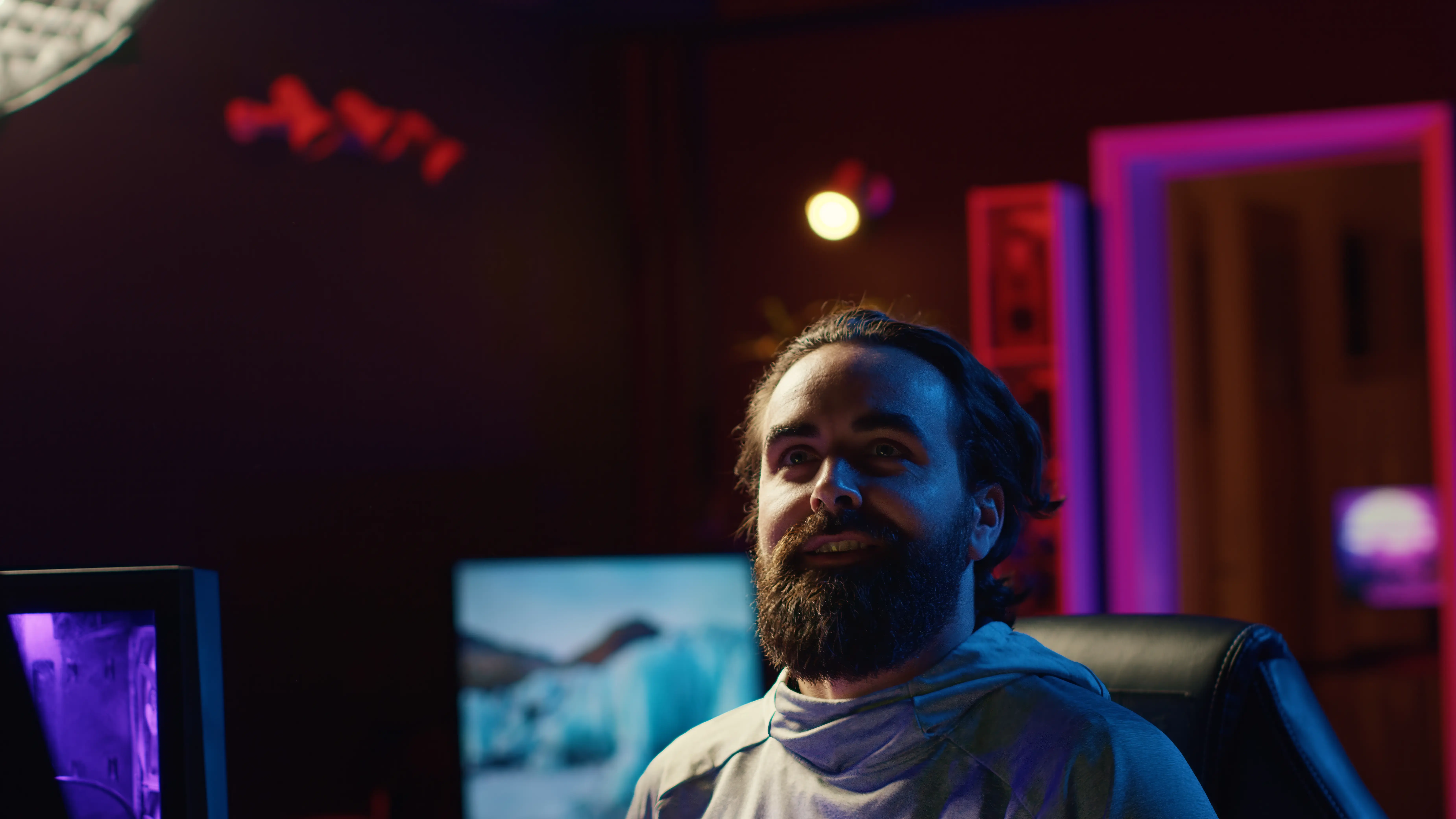 Person smiling at the camera in a dark room