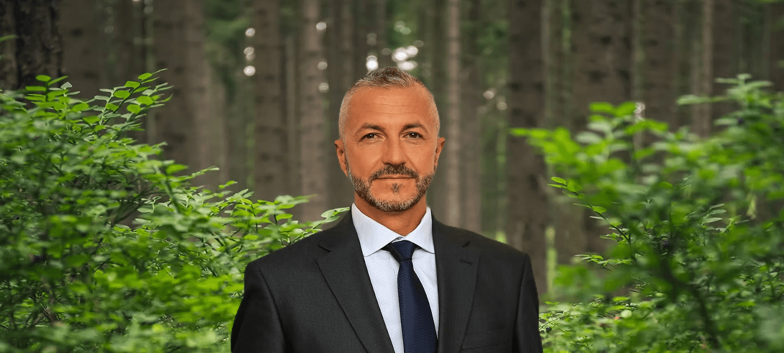 Mahir Zisko Sukalic, founder of Illyricum Investments, stands in a lush forest, symbolizing the vision for Illyricum City.