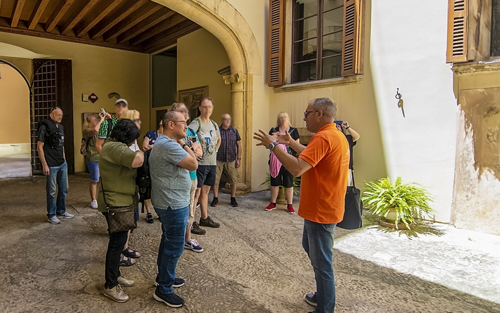 Grupo de turistas escuchando a un guía en la entrada de la Catedral de Palma.