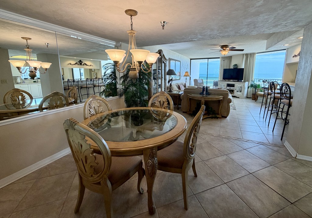 Dining area with a round glass table and chandelier, Unit 507 at The Ashley, a vacation rental in Daytona Beach Shores