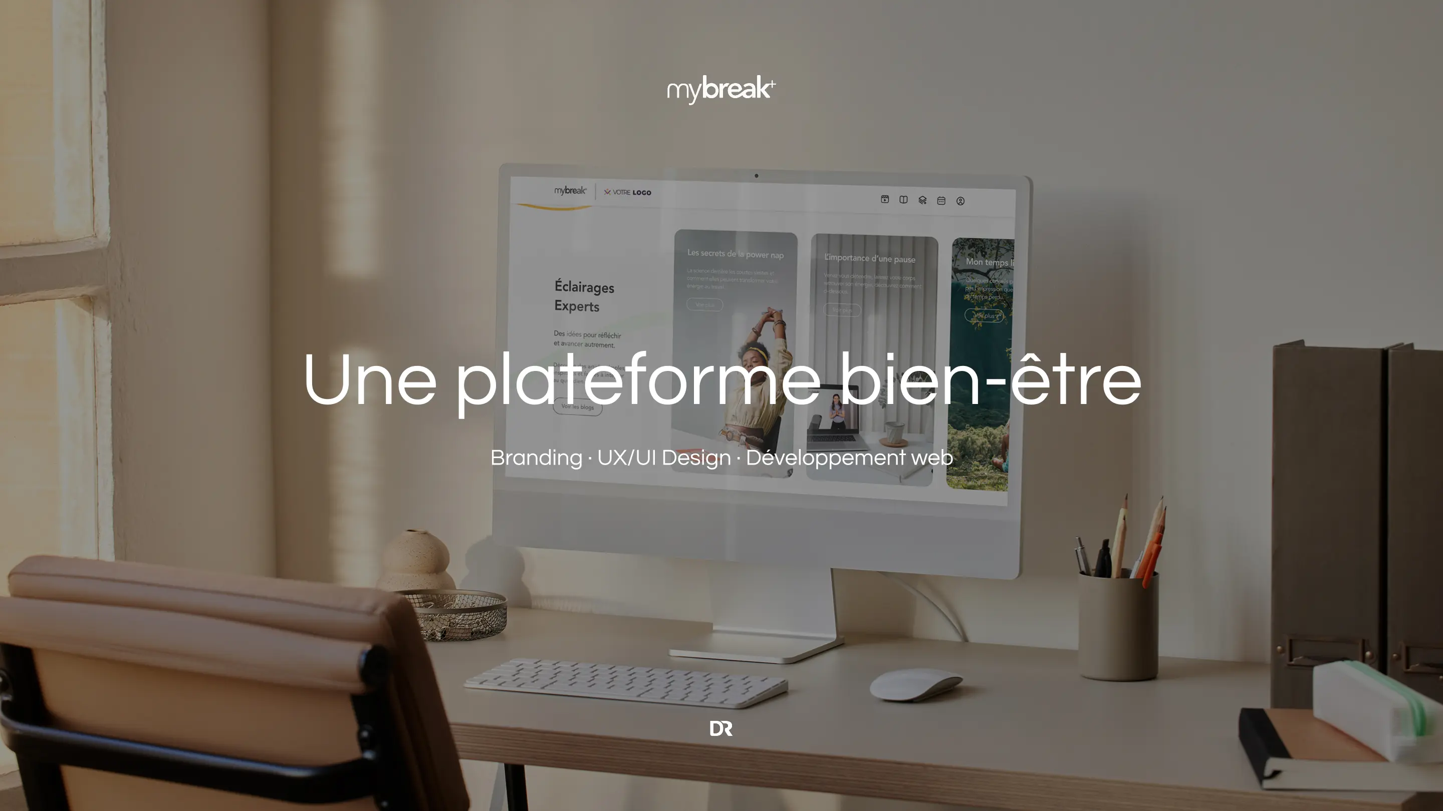 Poste de travail avec un écran affichant la plateforme MyBreak+, accompagné du titre Une plateforme bien-être et des expertises en branding, UX/UI design et développement web