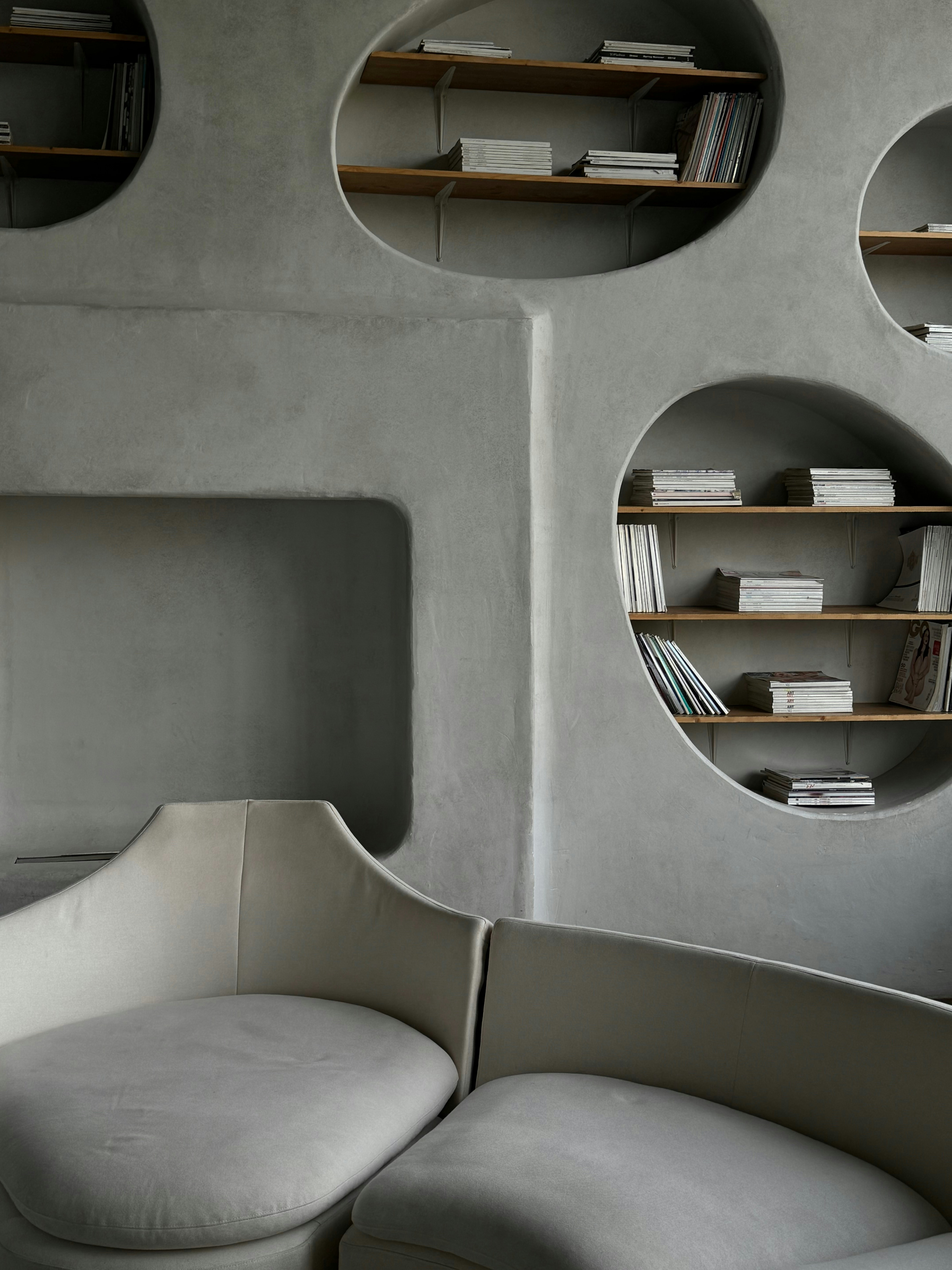 A living room with a couch a chair and shelves