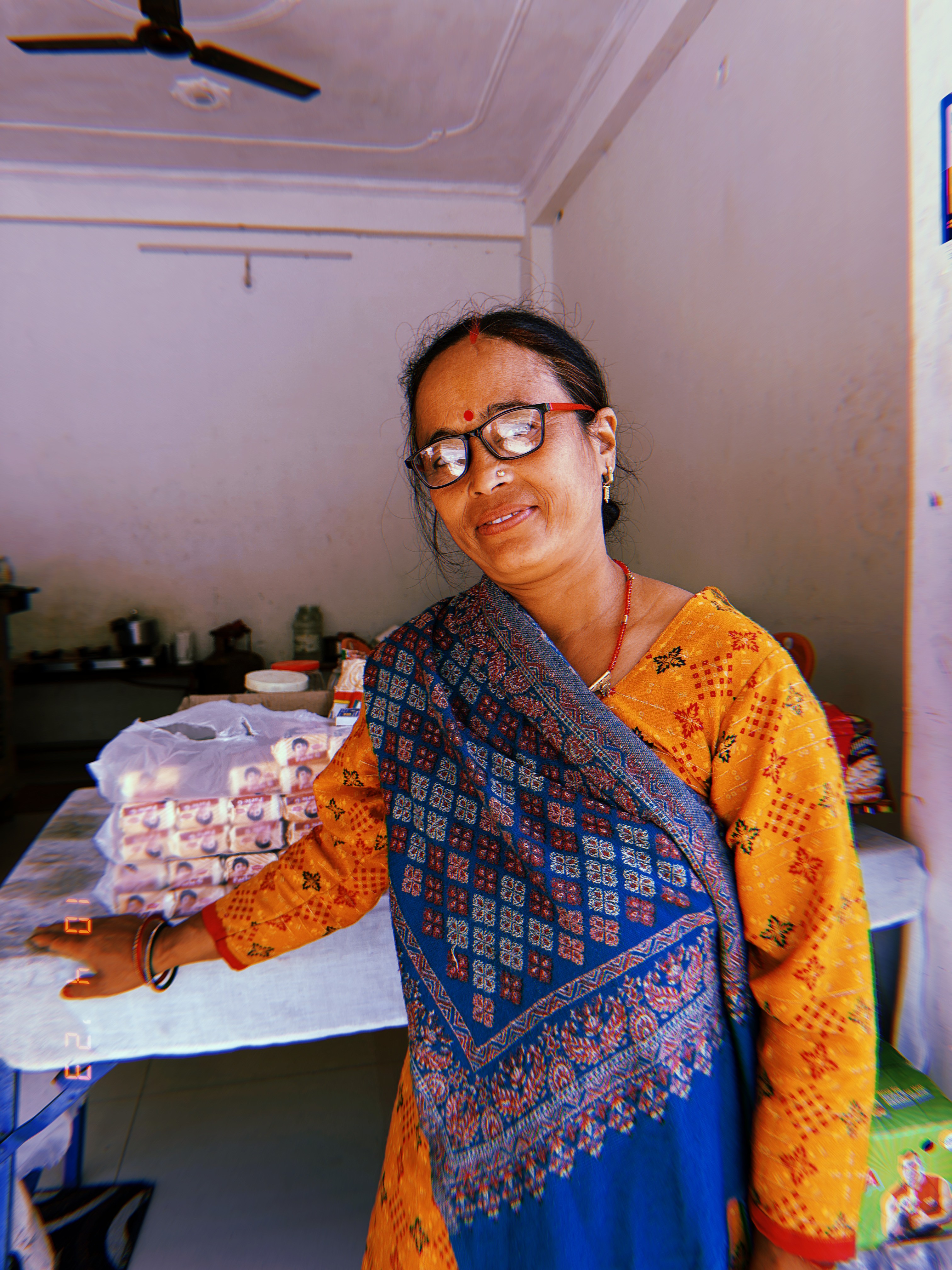 Woman wearing orange and a blue patterned shawl