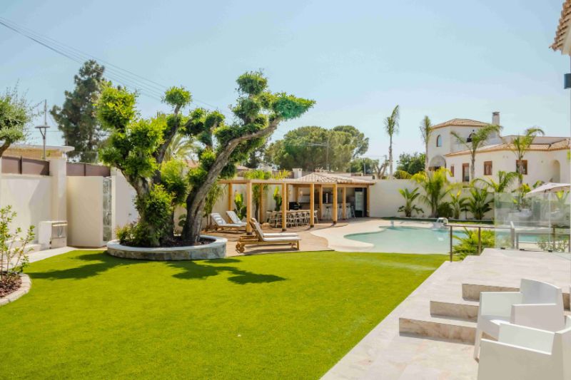 Luxurious backyard with pool, lounge chairs, and pergola.