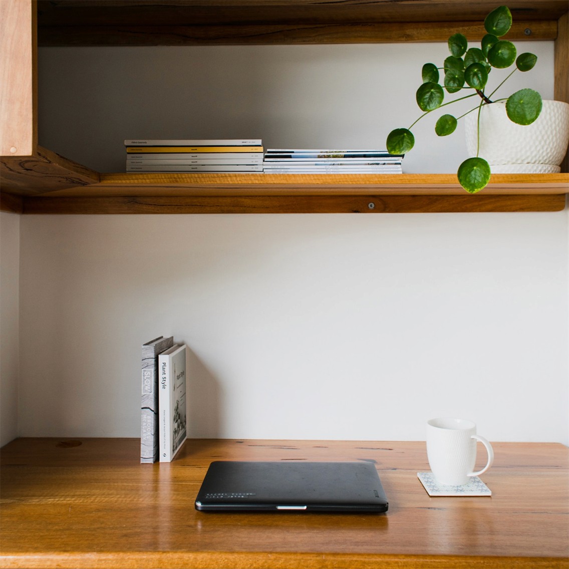 A laptop and a mug resting on a tabletop