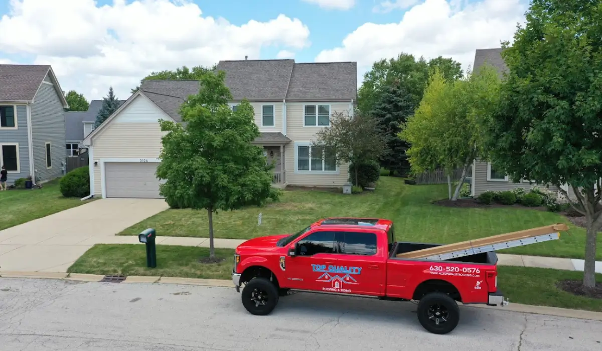 End-of-year roof inspection service vehicle parked outside Illinois home before winter roof repairs begin.