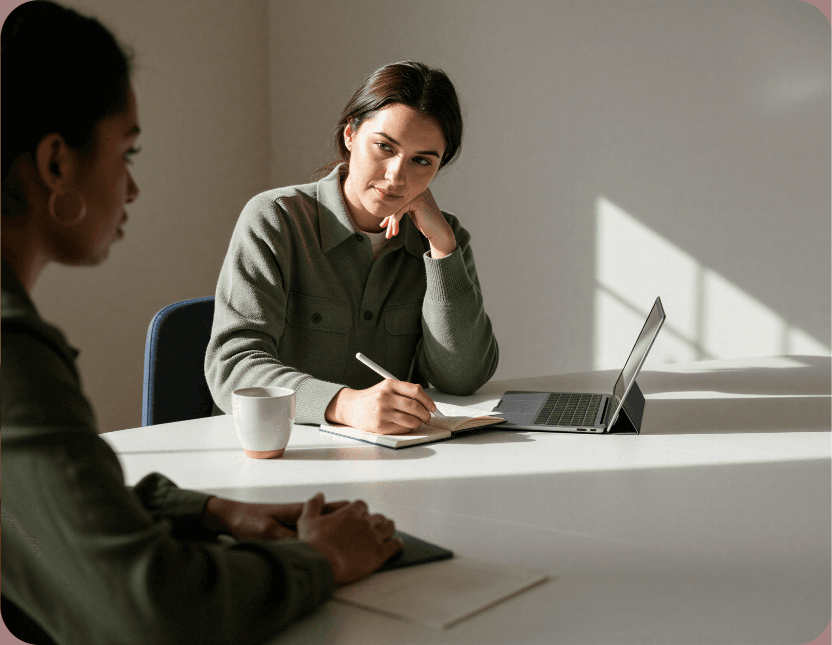 Woman taking notes during a meeting with a colleague.
