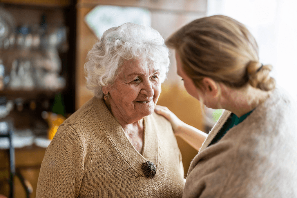 visitor talking to a senior woman during home visit