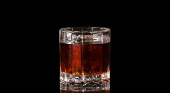 A closeup of a Savory, Year Round Black Russian drink against a dark background.