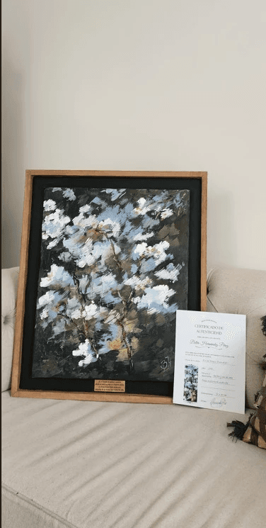 Painting of Belen on a couch next to a validation certificate