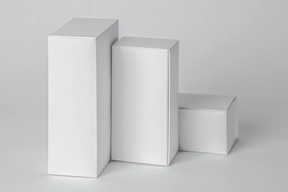 Set of three black product packaging boxes mockups with minimalist white typography. Displayed against a dark background with subtle lighting, emphasizing the sleek and modern design.