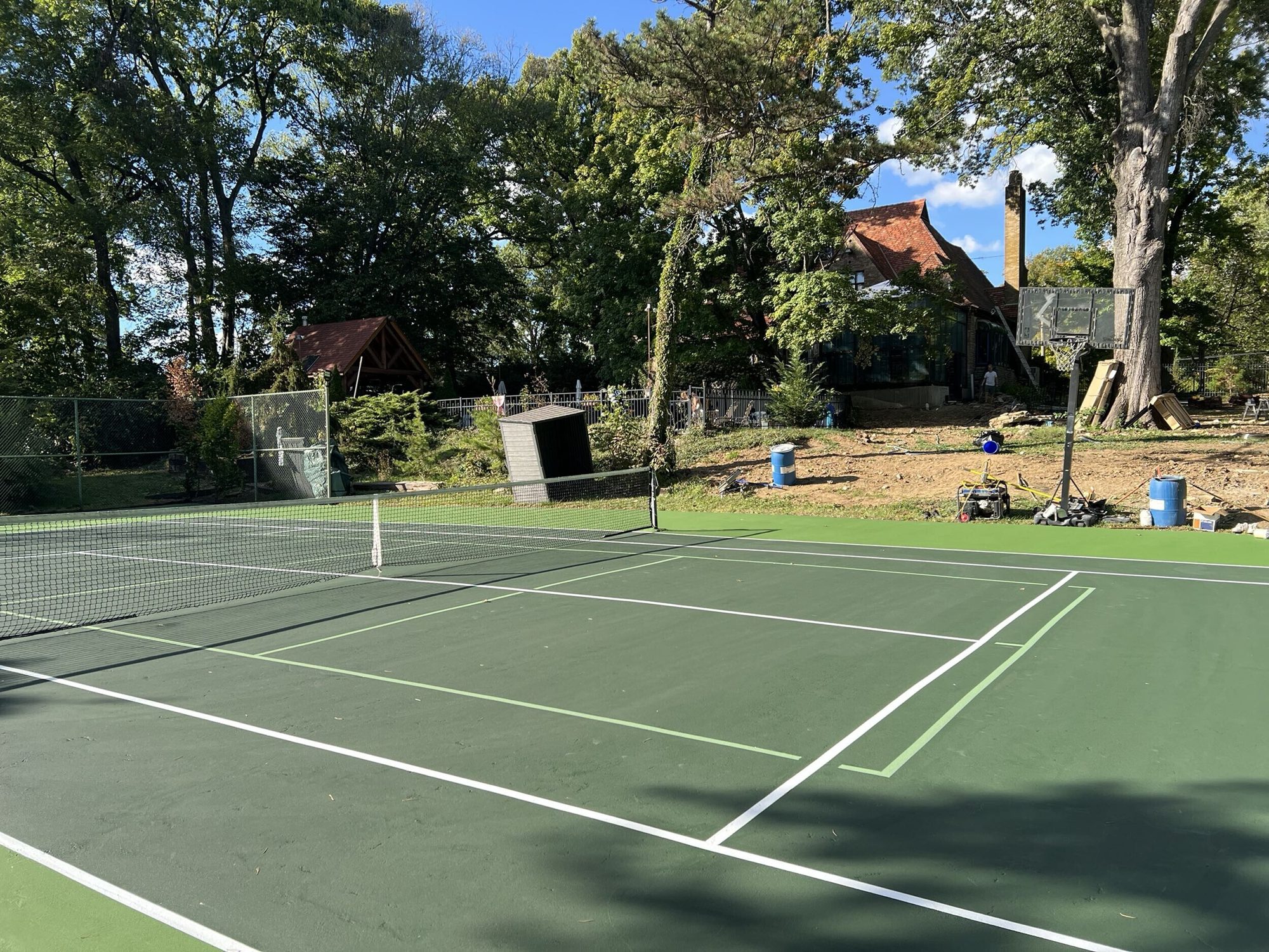 Resurfaced home tennis court surrounded by trees in Cincinnati, OH