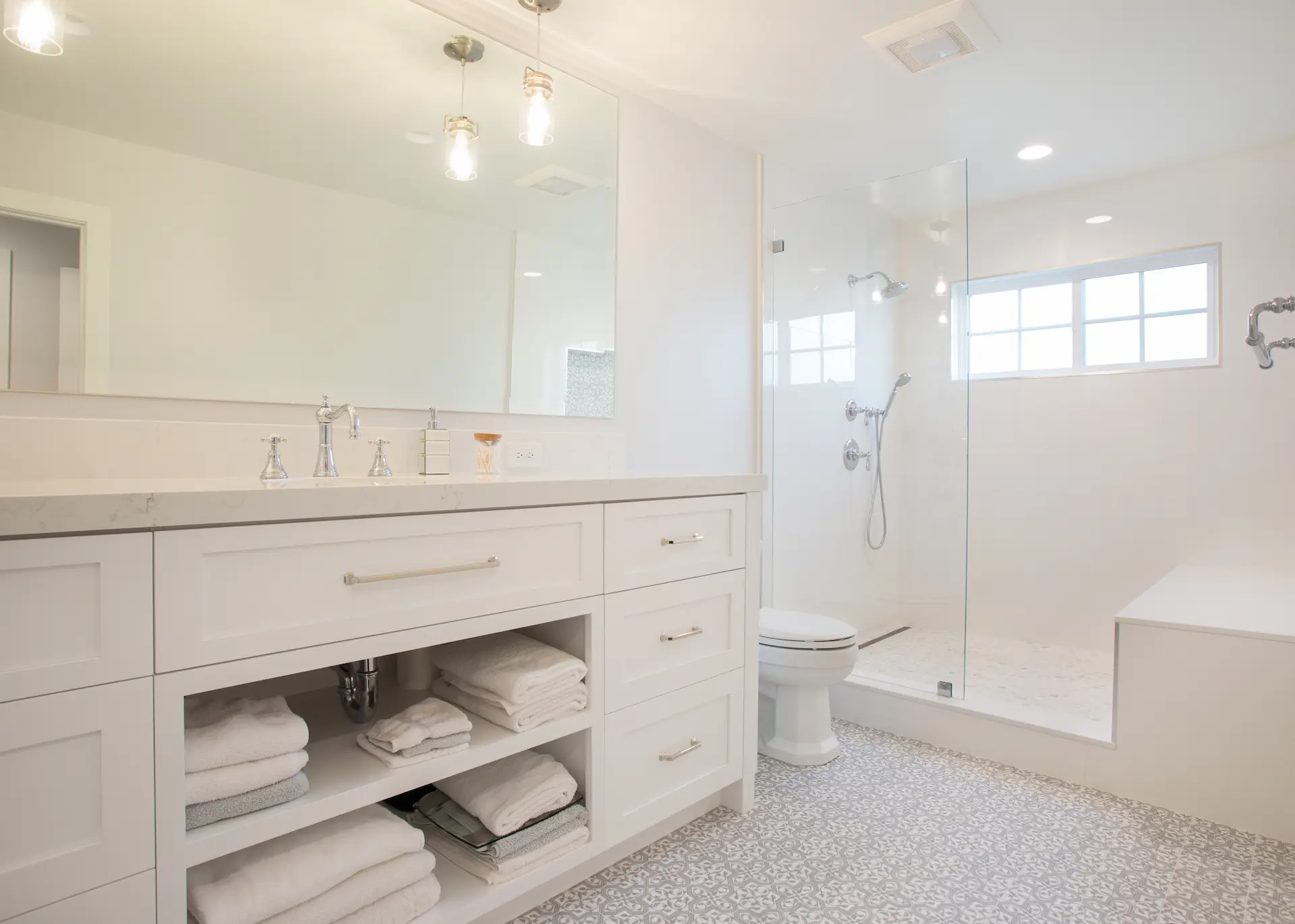 Luxurious bathroom with soft tones, custom vanity, and spacious walk-in shower with bench. From Dana Point Cape Cod remodel, photo by Chris Darnall.