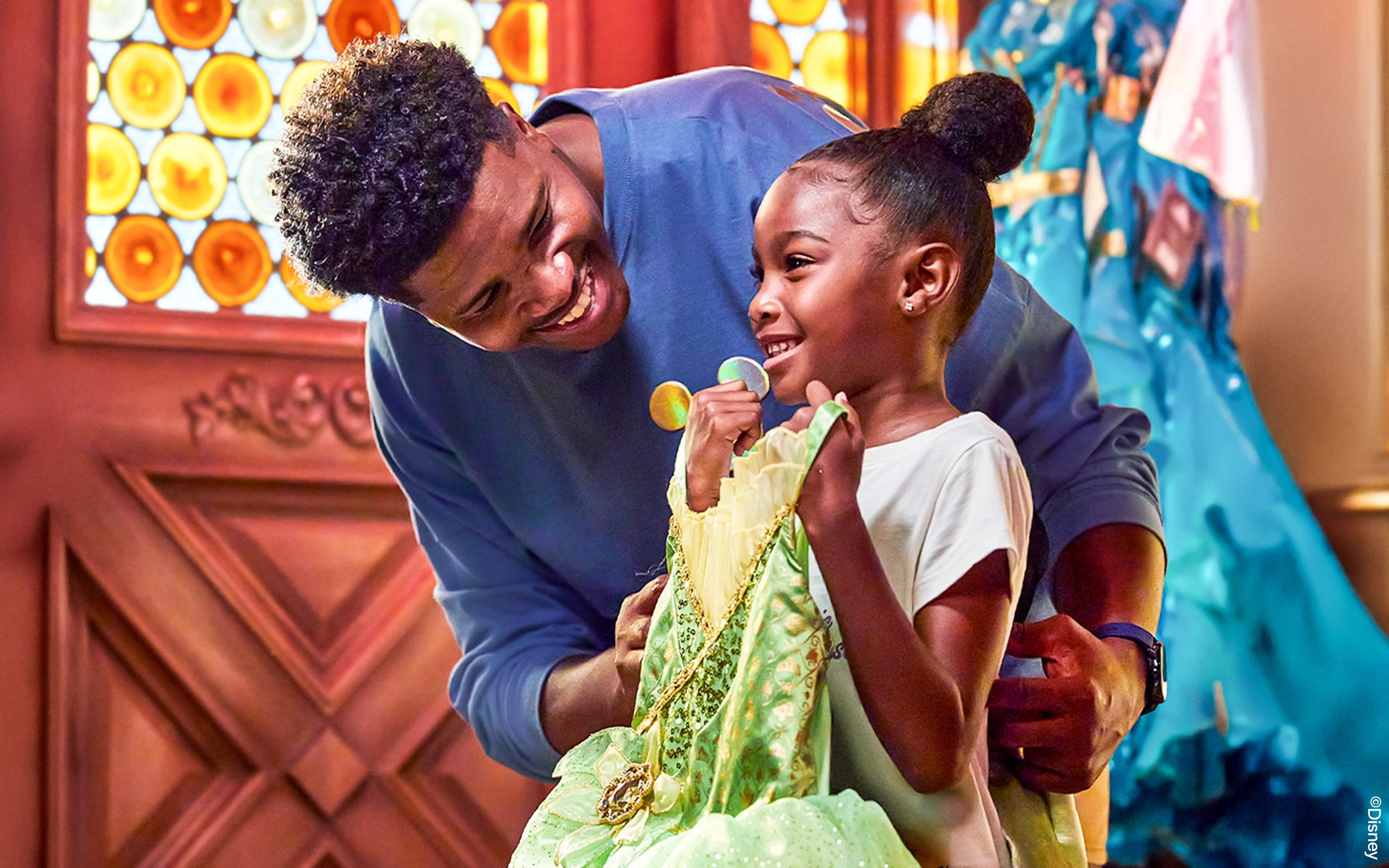 小孩在加州迪士尼乐园拿着公主裙。