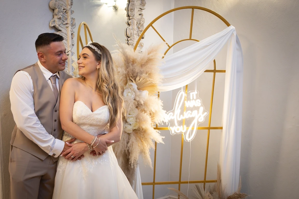 Lauren and Ethan posing indoors with soft lighting and wedding decor at Highfield Hall