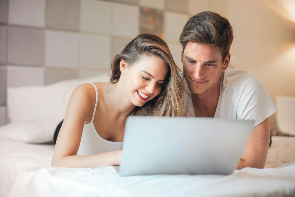 smiling couple laptop home