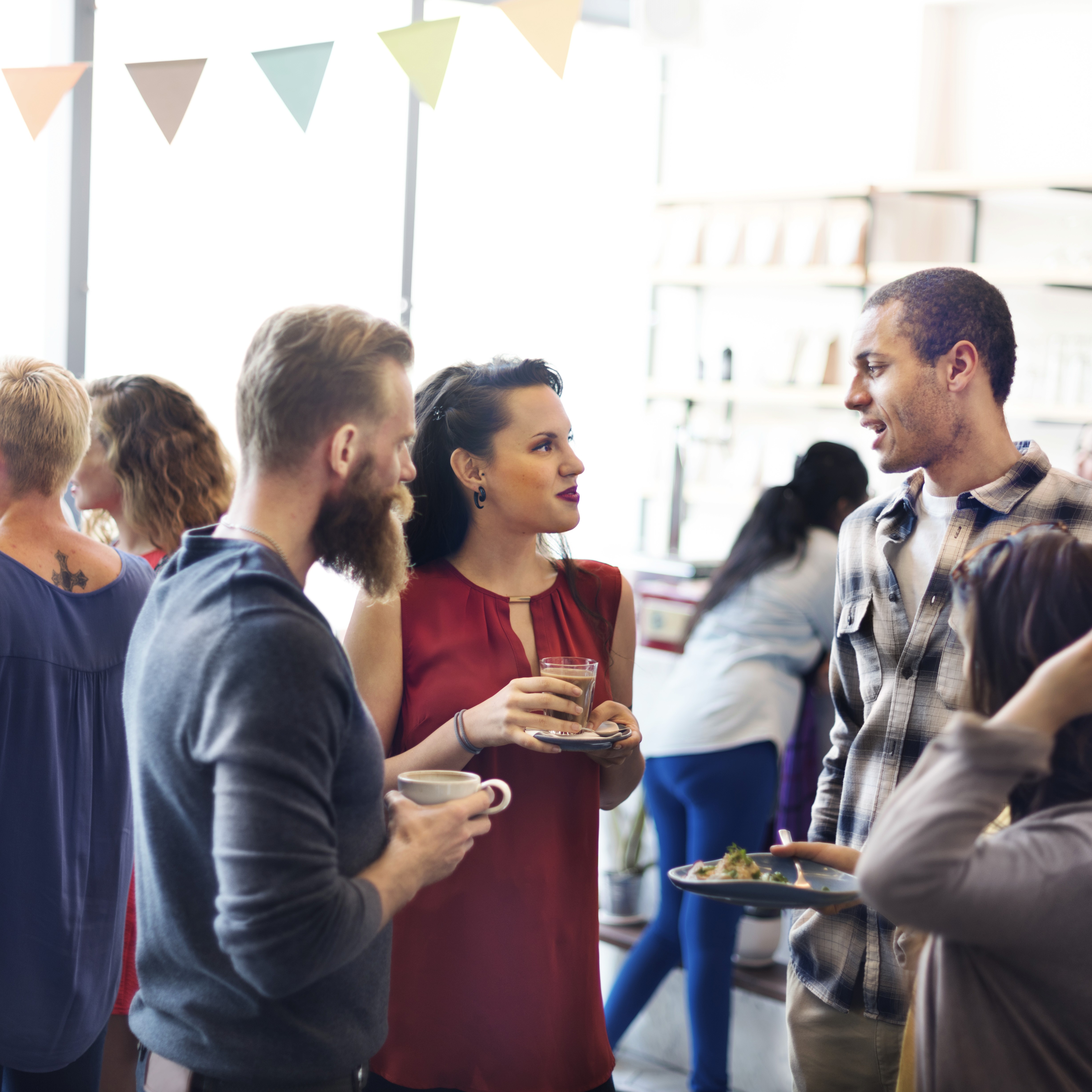 A group of people talking at an office party