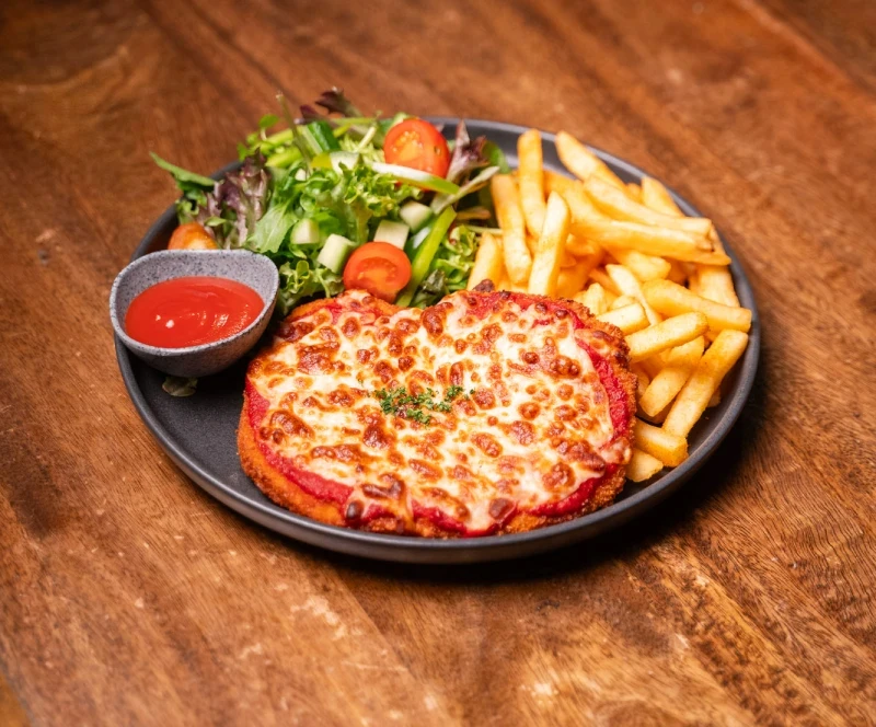 Parma on a plate with chips and salad