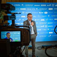 Interviewaufnahme am 7. Immobilien-Summit vor Sponsoren-Wand
