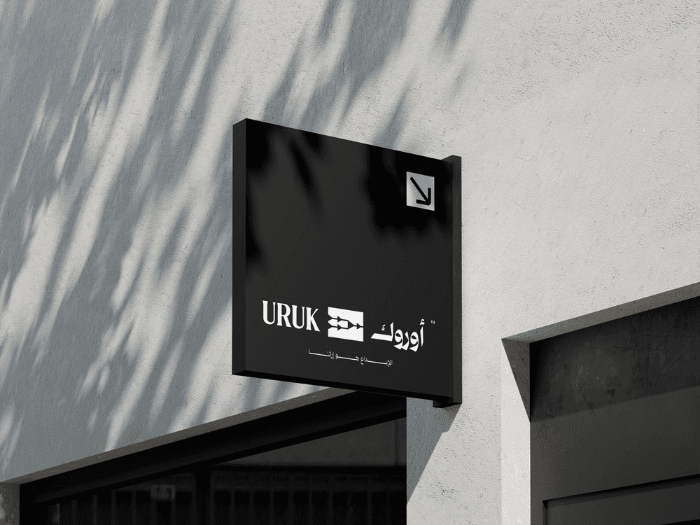 Uruk brand signage with bold Arabic and English logo inspired by cuneiform symbols, representing timeless Mesopotamian heritage in a modern identity system.