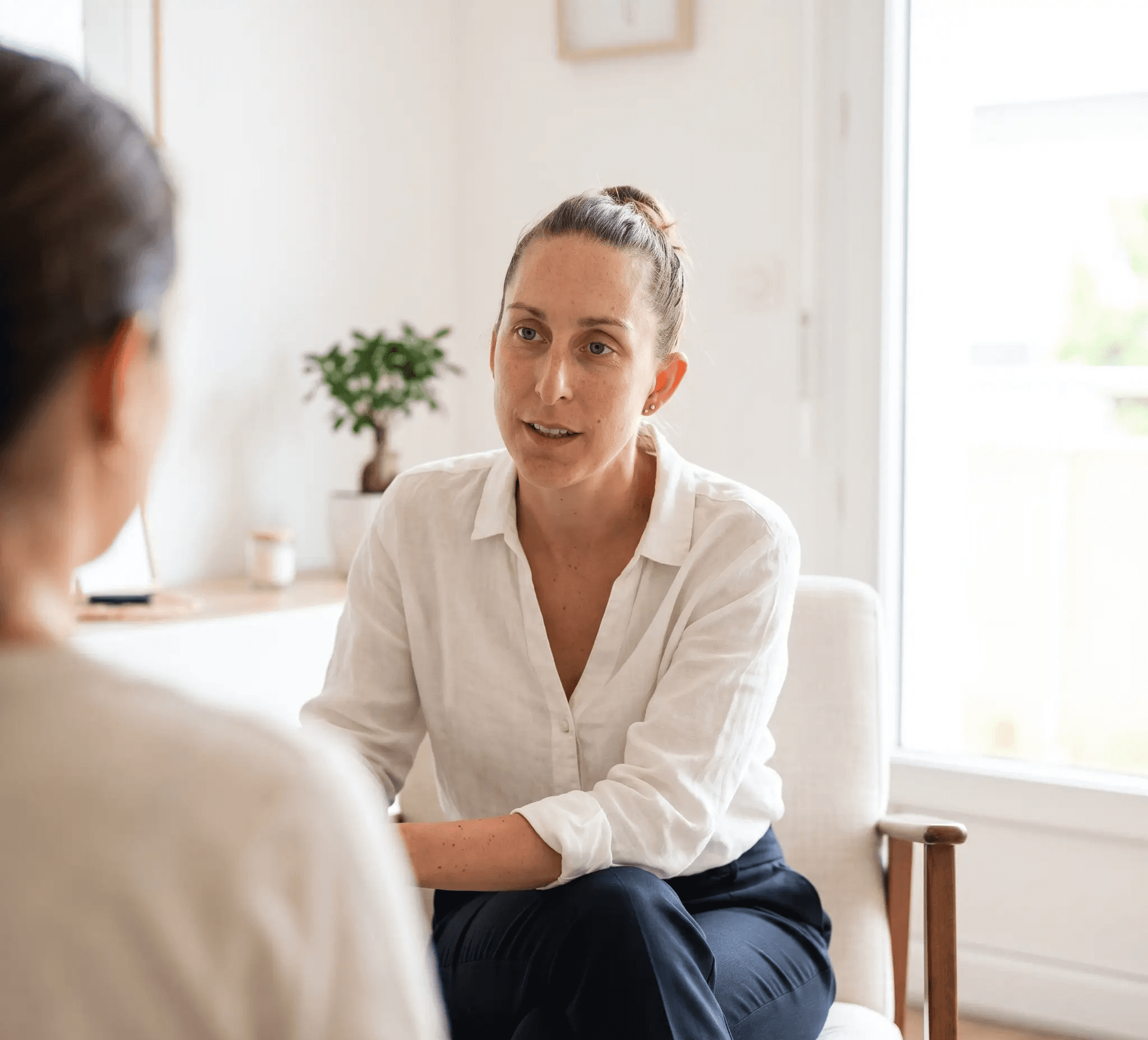 a woman sitting on a couch talking to a man