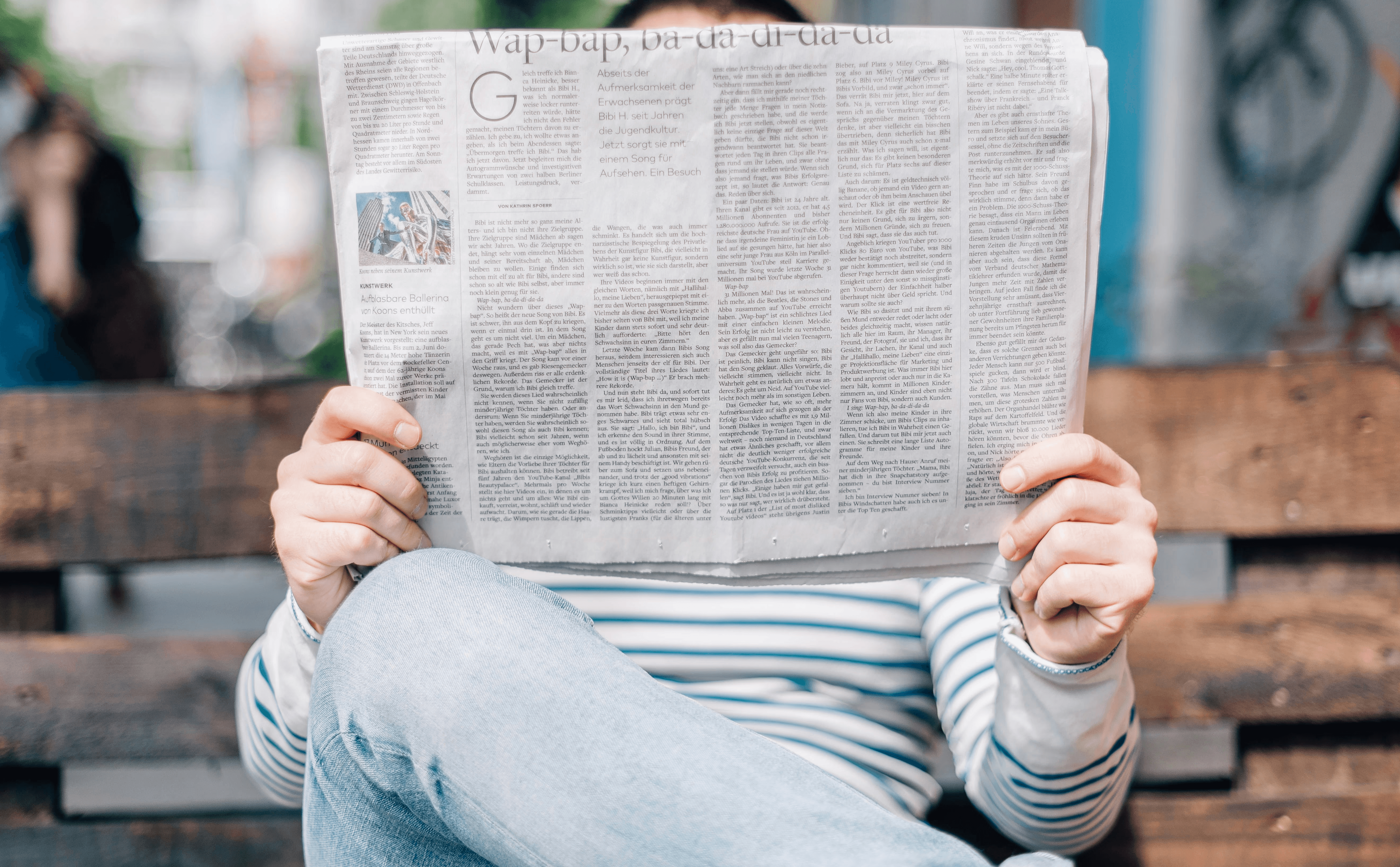 Mann auf Bank der die Nachrichten liest. Sinnbild für PR und Öffentlichkeitsarbeit.