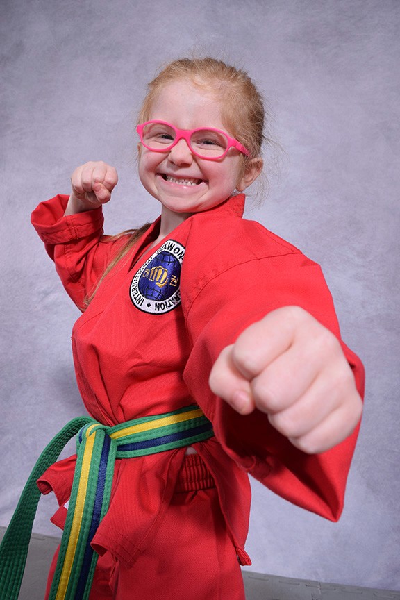 Martial Arts Student posing with a big smile and punch