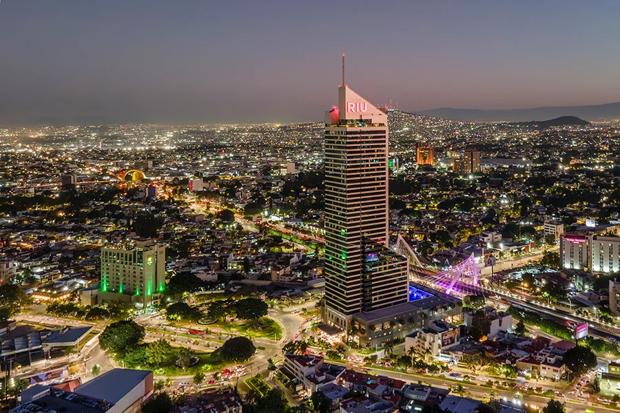Fachada del Hotel Riu Guadalajara iluminada con diseño arquitectónico y ventanas de gran formato