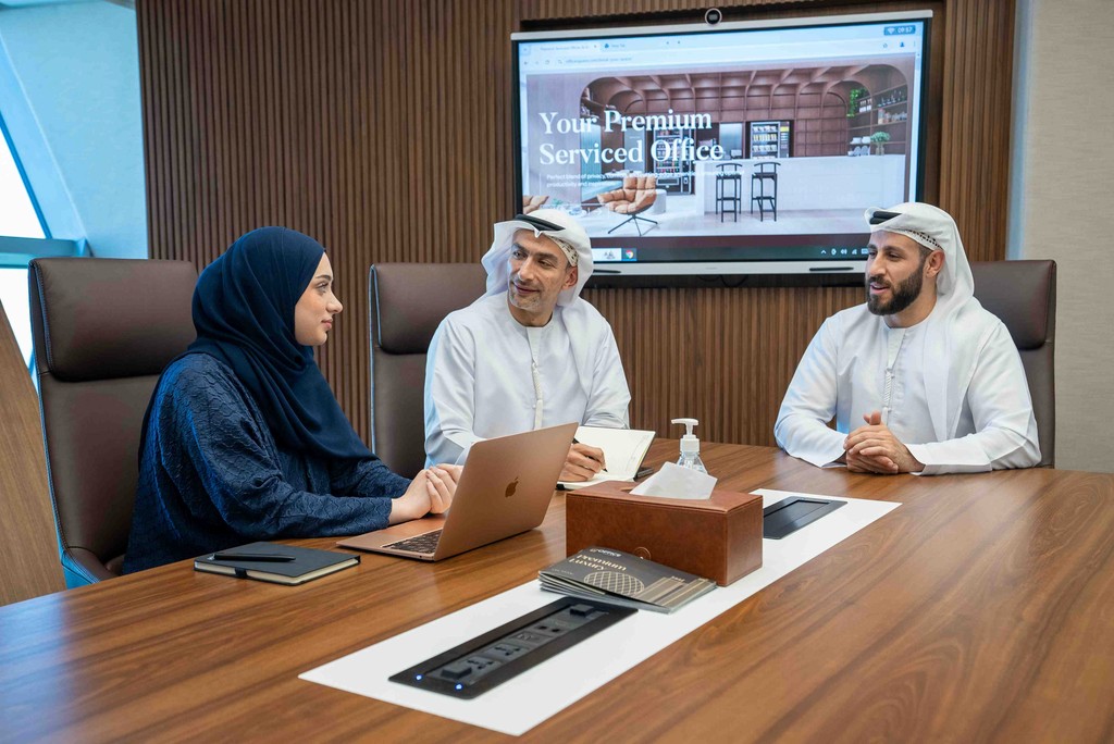 Team discussion taking place in a private meeting room in Abu Dhabi.