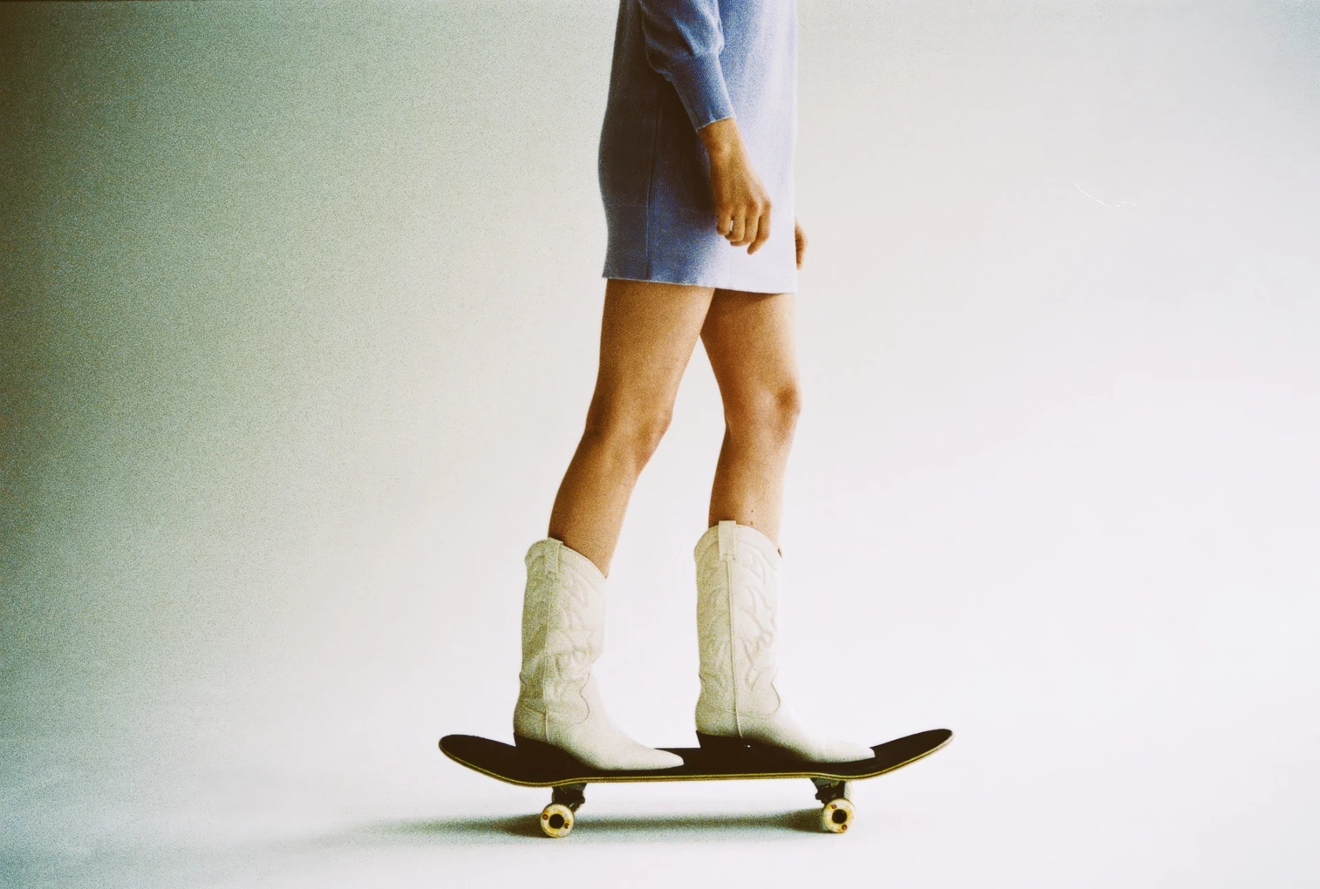 Person steht auf einem Skateboard vor neutralem Hintergrund – Sinnbild für Balance, Dynamik und modernes Webdesign.