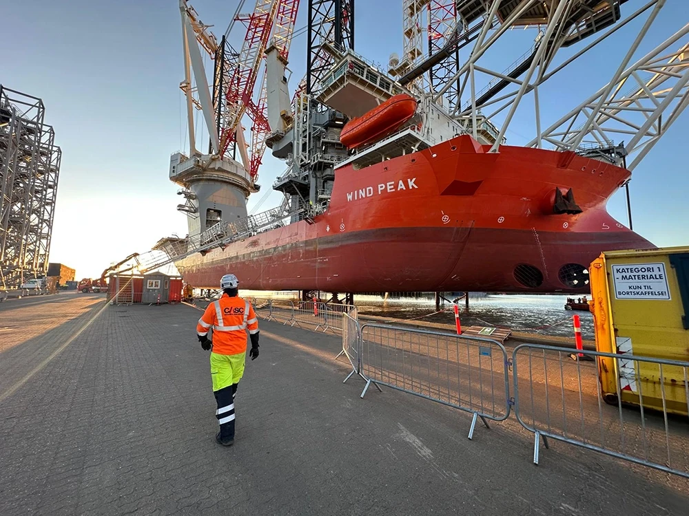 CASC employee walking alongside the Wind Peak offshore installation vessel at port
